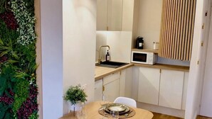 Cocina pequeña con microondas, pileta y muebles de madera.