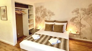 Un dormitorio con cama, armario, mesita de noche y un mural en la pared.
