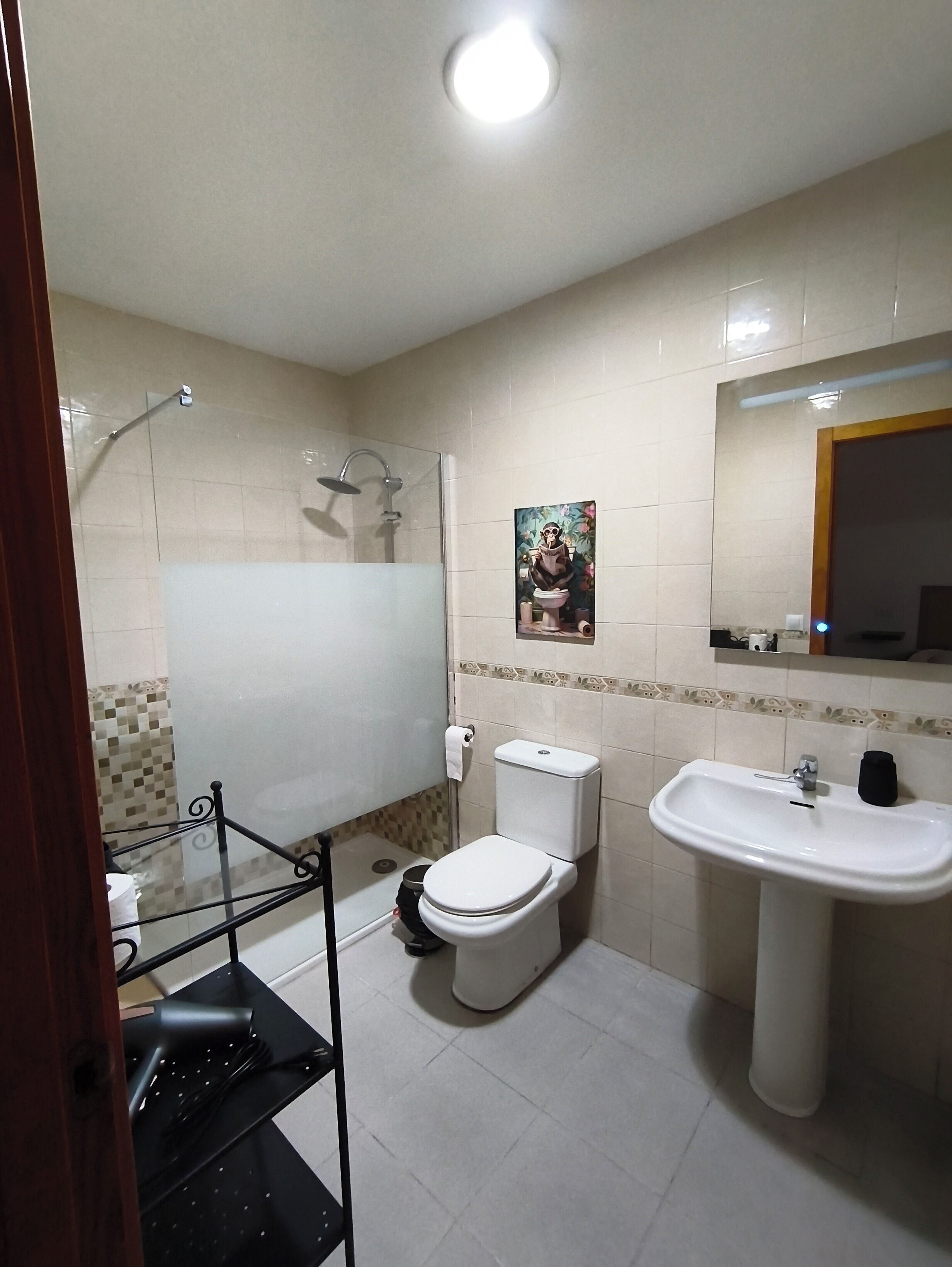 A bathroom with a toilet, sink, and shower.