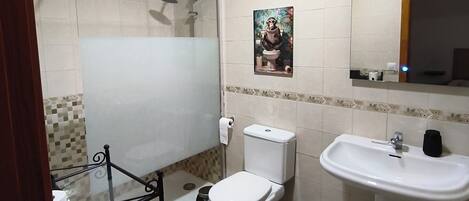 A bathroom with a toilet, sink, and shower.