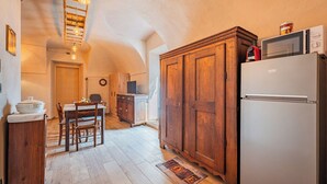 Une cuisine avec des meubles de rangement en bois, un réfrigérateur blanc et un coin repas comprenant une table et des chaises.