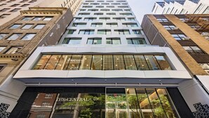 A modern building with a glass facade, a prominent entrance labeled 'The Central 5th Hilton Club,' and a view of the surrounding urban environment. - Luxury NYC Stay Near Fifth Ave, Central Park & Rockefeller Center Studio Plus (New York City)