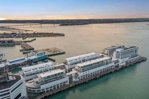 A waterfront hotel with multiple buildings, a dock, and a bridge in the background. - Princes Wharf Harbour View Studio (Auckland Central)