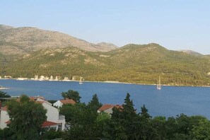 A coastal view with mountains, a body of water, and buildings in the foreground. - A5 - Luxurious 1-Bedroom for 3: Elegant Design & Unmatched Breathtaking Views of Slano Bay (Slano)