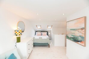A bedroom with a bed, bedside tables, a lamp, a painting, and skylights. - Charming 2BR Cottage in Richmond, 20 mins C London - Pass the Keys (Richmond)