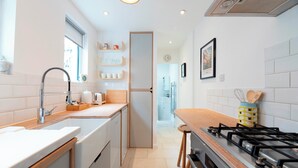 Cocina moderna con lavamanos, estufa y encimera de madera.