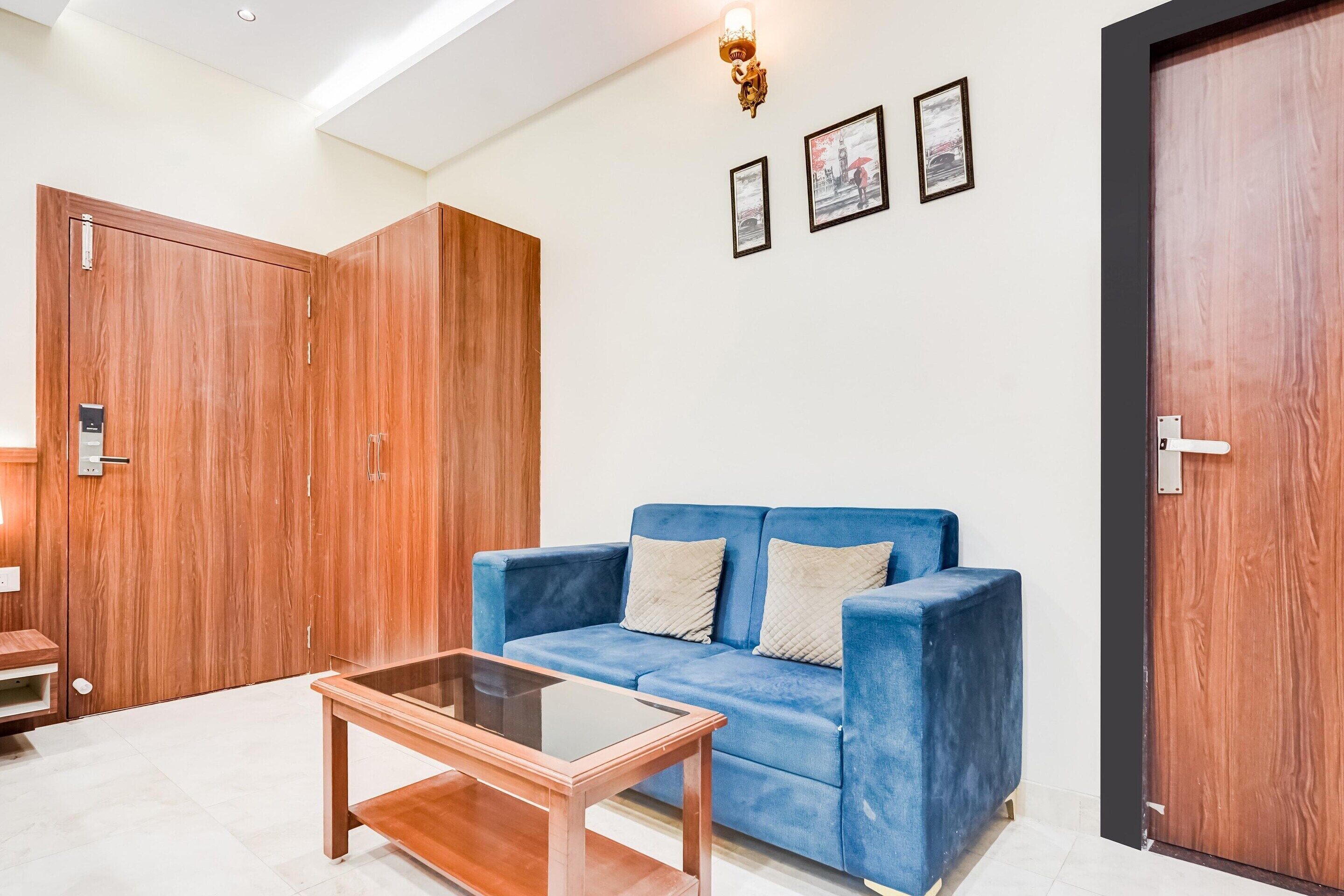 A room with a blue sofa, a wooden coffee table, and a wardrobe.