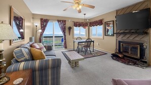 A living room with a sofa, dining table, chairs, a fireplace, and a ceiling fan. - Above the Clouds Views, Fireplace, Near Ski Resort (Beech Mountain)