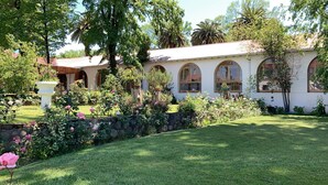 Un edificio con ventanas arqueadas y un jardín con diversas plantas y flores.