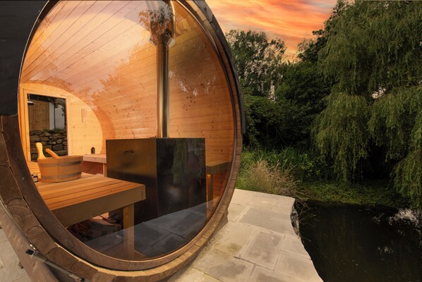 Une cabane en bois avec une fenêtre ronde, un mur de pierre et une table en bois.