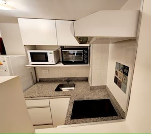 A compact kitchen with a microwave, toaster oven, and a sink. - Buenos Aires I Downtown New studio, center (Buenos Aires)