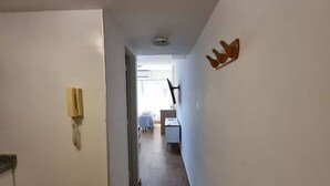 Ein Flur mit Telefon, Schreibtisch und Stuhl im Hintergrund.