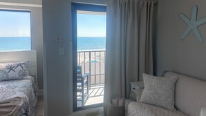 Een kamer met een bed, een stoel, uitzicht op het strand en een zeester decoratie.