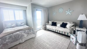 Een slaapkamer met een bed, een bank, een lamp, een speaker en decoratie van zeesterren aan de muur.