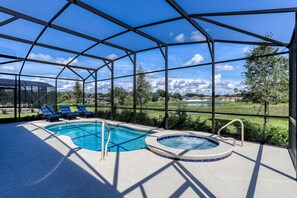 A covered outdoor swimming pool with lounge chairs and a hot tub, surrounded by a metal frame and glass panels. - Large Open-concept Home With Private Pool, Pool Table-dogs Welcome (Davenport)