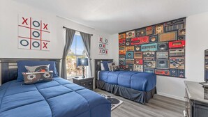 A room with two beds, a wall with vintage radio tapes, and a window with curtains. - Magical & Cozy Disney Retreat at Regal Palms Resort (Davenport)