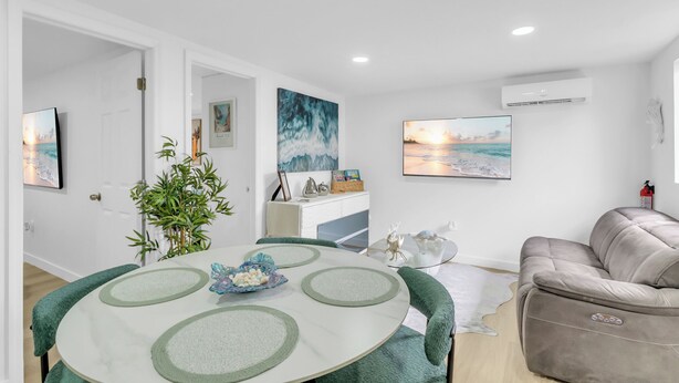 Ein modernes Wohnzimmer mit einem runden Esstisch, einer Couch und Kunstwerken an den Wänden.