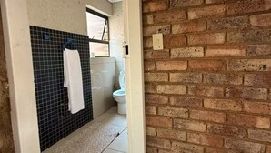 Casa de banho com chão em azulejos, lavatório branco e sanita.