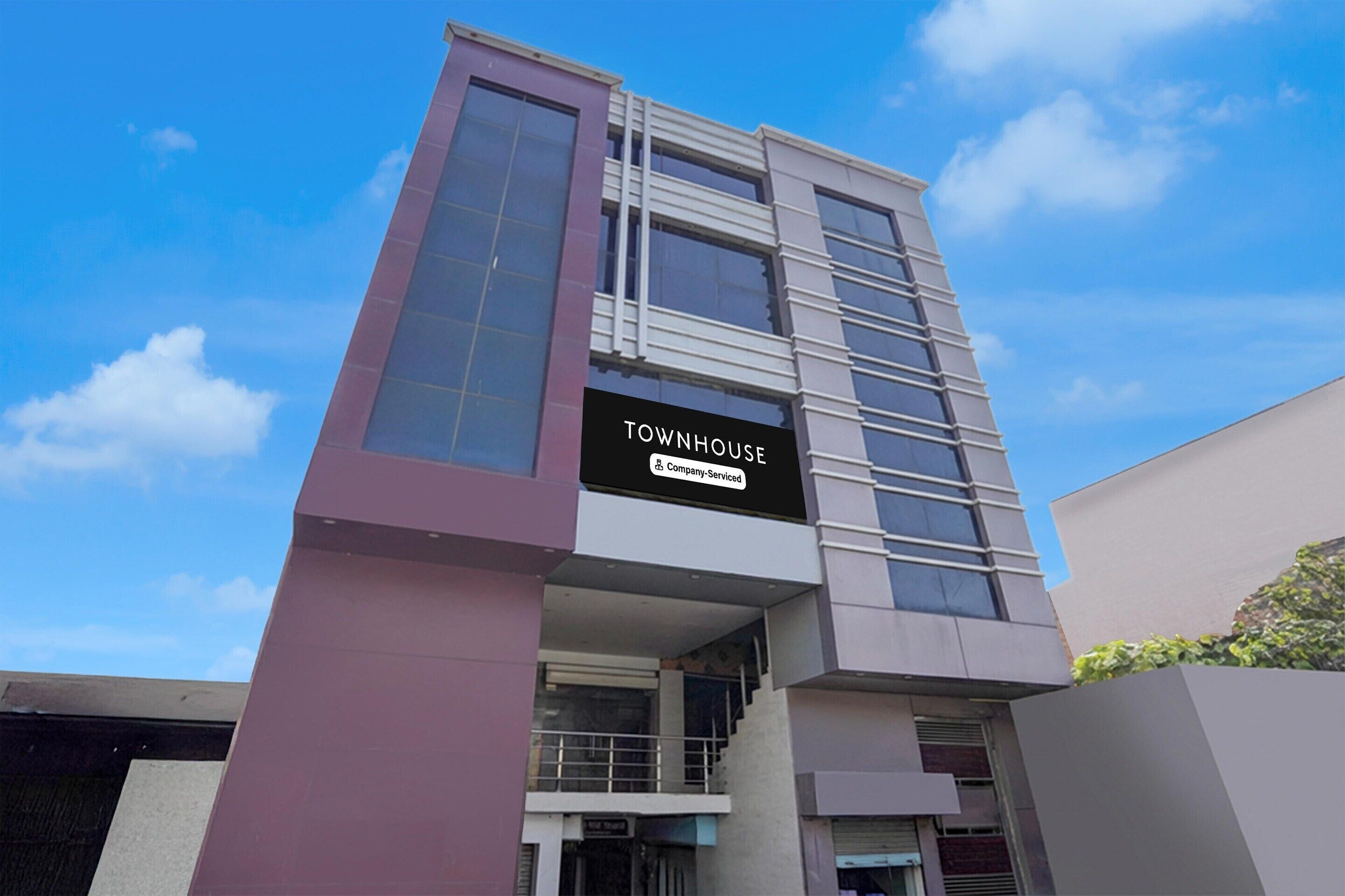 Un edificio moderno con un cartel que dice 'TOWNHOUSE & Company-Serviced'.