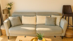 A living room with a sofa, a coffee table, a lamp, and a chair. - Magnifique duplex vue mer avec clim, wifi, piscine, mer à pied (Serra-di-Ferro)