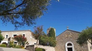 A stone building with a large arched doorway, a small attached structure with a chimney, and a paved driveway. - Magnifique duplex vue mer avec clim, wifi, piscine, mer à pied (Serra-di-Ferro)