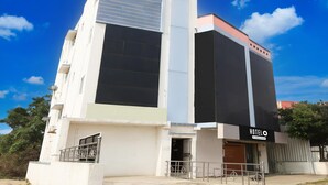 A hotel with a modern design, featuring a large entrance, a balcony, and a signboard. - Hotel O Oragadam Industrial Estates Chennai (Walajabad)