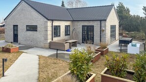 A modern house with a brick exterior, large windows, and a patio area with outdoor furniture. - 4 bedroom lovely home in Malling (Malling)