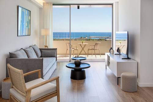 Appartement supérieur, 2 chambres, balcon, vue sur la mer | Aire de séjour | Téléviseur connecté