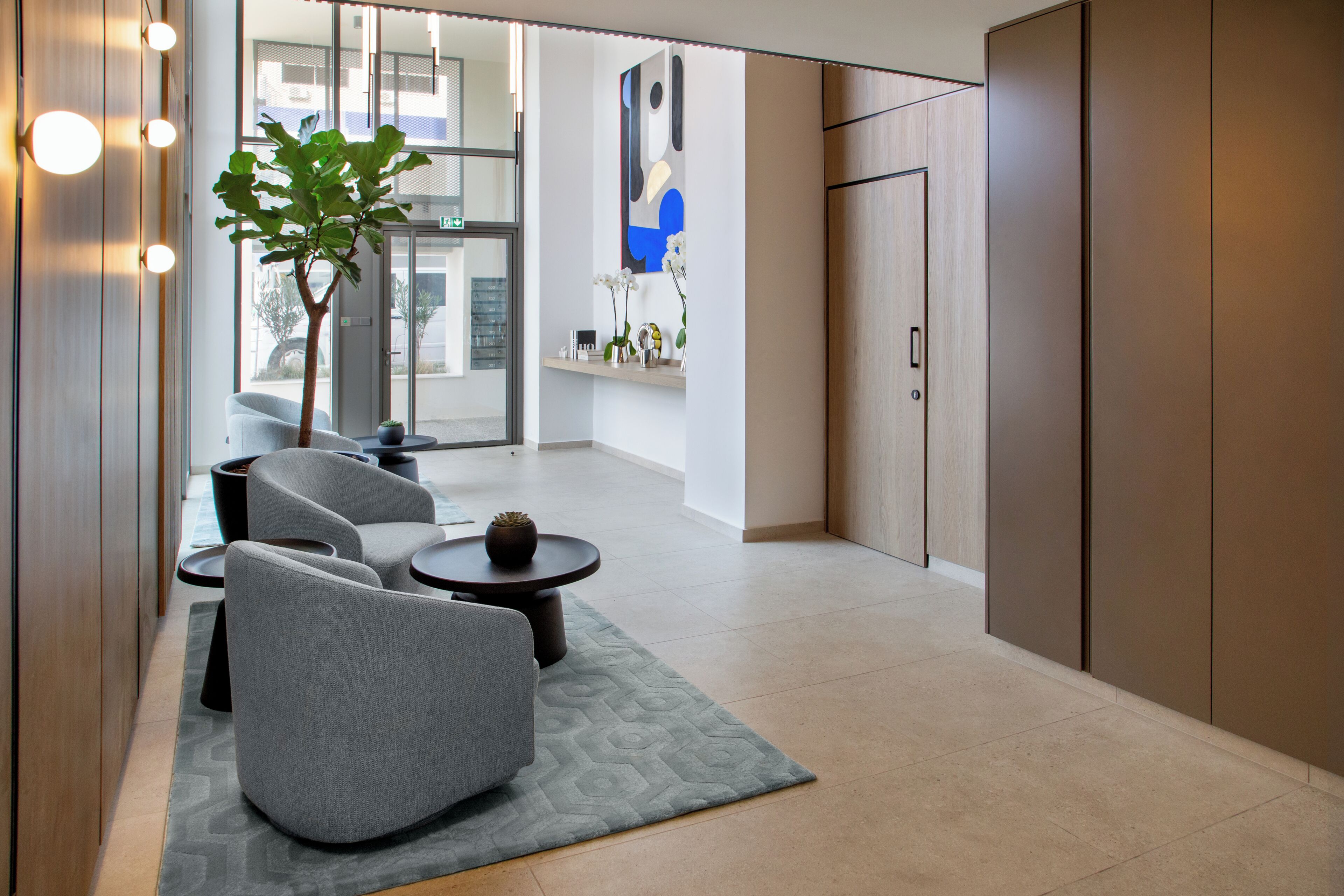 Ein modernes Interieur mit einer Sitzecke, einem Topfpflanzen und einer Tür zu einem weiteren Raum.