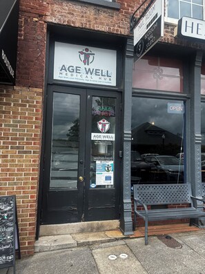Une devanture de magasin avec une enseigne indiquant « AGE WELL MEDICAL HUB » et une autre indiquant « SALON D’ONGLES OUVERT ».