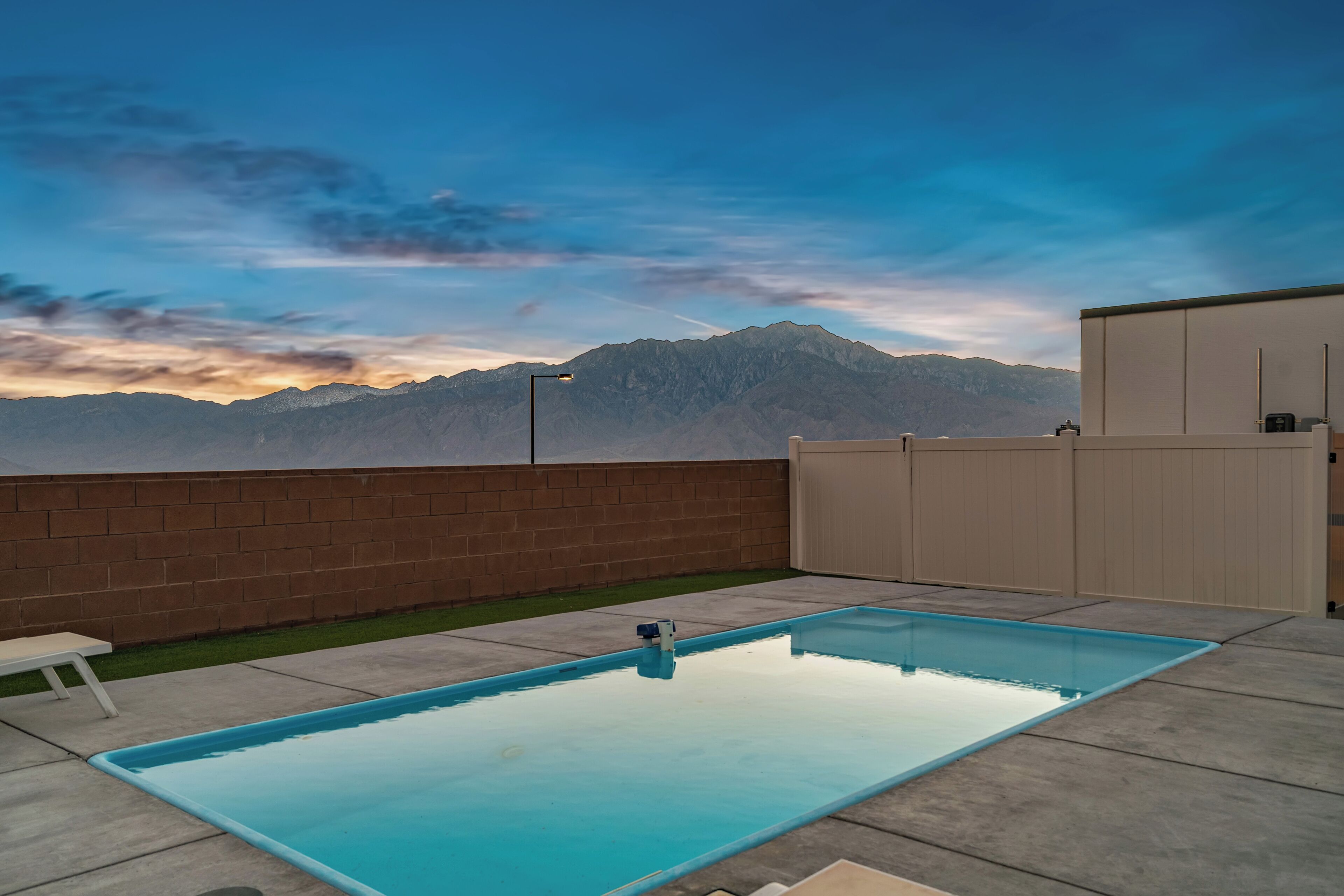 Una piscina rectangular con una vista despejada de montañas al fondo.