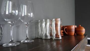 A wooden table with various glassware and ceramic items.