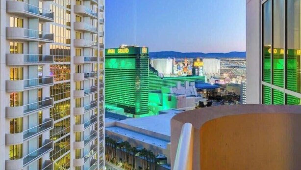 Ein Hochhaus mit mehreren Balkonen, Blick auf einen Casino-Komplex und einem klaren Himmel.