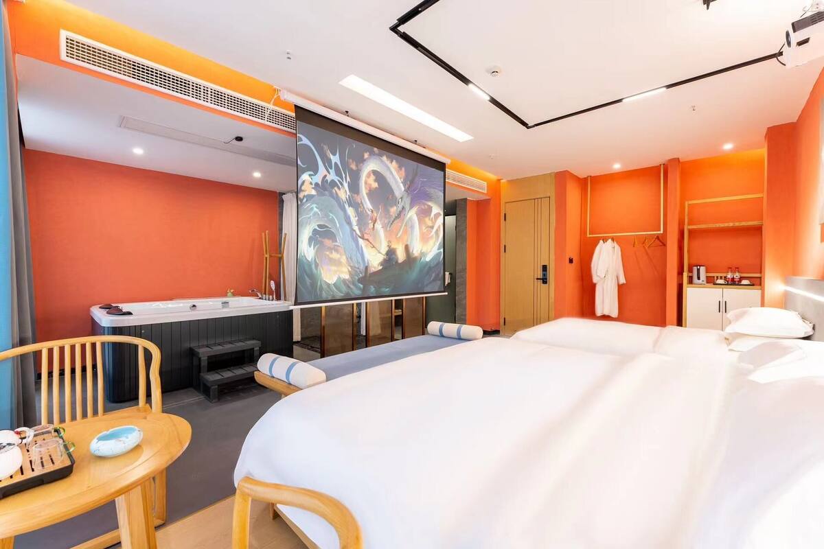 Una habitación de hotel con una cama grande, un escritorio con una silla, un televisor y un baño con bañera.