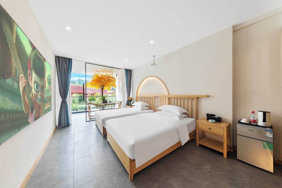 Habitación de hotel con dos camas, un escritorio, un refrigerador y vistas al exterior.