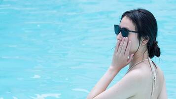 Una persona en una piscina con una cesta que contiene comida y bebidas.