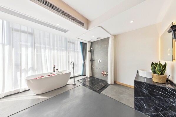 A modern bathroom with a freestanding bathtub, a shower area, and a marble countertop with a potted plant. - Twelve Cities Mountain View Hot Spring-Pool Holiday Homestay Near Waterfall-English Service-Free Shuttle from Furong Town High-speed Railway Station (Xiangxi)