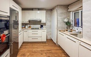 A compact kitchen with white cabinetry, a built-in oven, and a wooden floor. - 2 bedroom nice apartment in Conil de la Frontera (Conil de la Frontera)