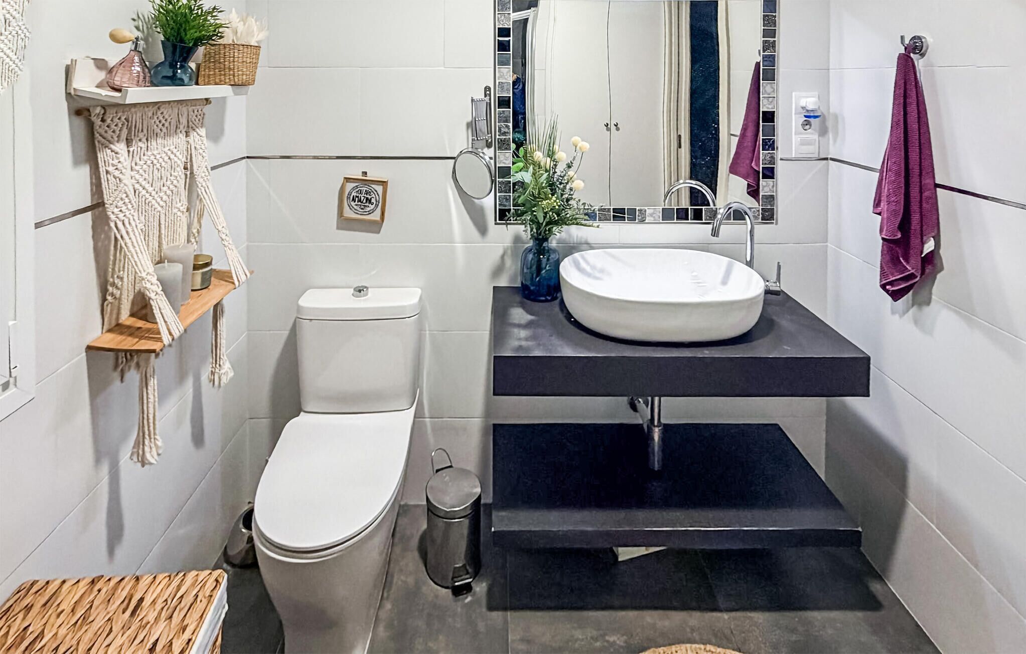 Un baño moderno con inodoro, lavamanos y espejo.