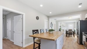 A modern kitchen with a wooden island, white cabinetry, and stainless steel appliances. - New Listing! The Landing Pad - 8 minutes to ATL Airport! (Atlanta)