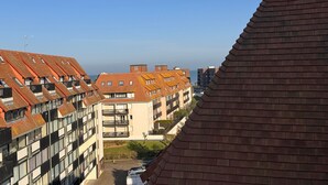 A residential building with a sloped roof, multiple balconies, and a view of the sea. - Bright duplex near the beach - 4 guests (Villers-sur-Mer)