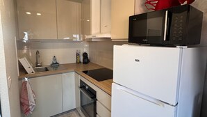 A compact kitchen with a microwave, a white refrigerator, and a dishwasher. - Bright duplex near the beach - 4 guests (Villers-sur-Mer)
