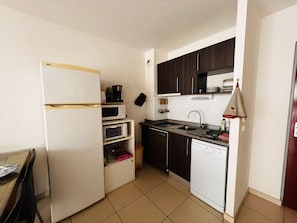 A compact kitchen with a refrigerator, microwave, oven, sink, and dishwasher. - Air-conditioned apartment near the beach - 4 guests (Argelès-sur-Mer)