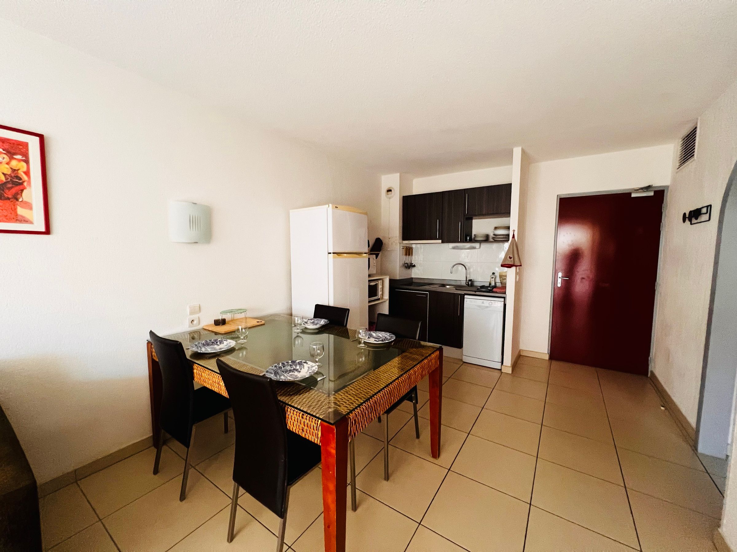 A compact kitchen with a refrigerator, microwave, and sink.