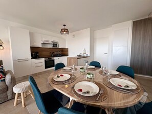Een moderne keuken met witte kastjes, een magnetron en een vaatwasser.