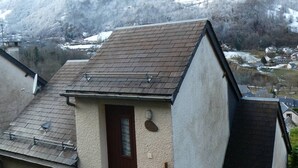 Ein Wohngebäude mit geneigtem Dach, einer kleinen Tür und einer Satellitenschüssel.
