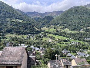 Un valle con casas y una montaña al fondo.