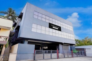 A modern building with a sign reading 'TOWNHOUSE' and a gated entrance. - Deluxe Grace Complex (Chennai)