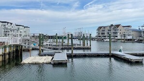 A marina with docked boats, a pier, and buildings in the background. - Harbor Front Condo. Minutes to downtown. (Cape May)