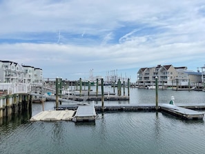 A marina with docked boats, a pier, and buildings in the background. - Harbor Front Condo. Minutes to downtown. (Cape May)